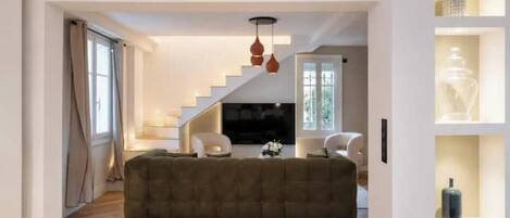 Uma sala de estar moderna com escada, um sofá e uma mesa de centro.