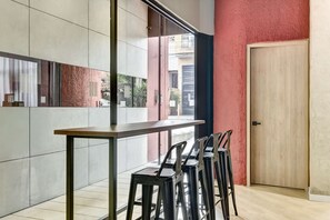 A modern interior with a long table and black bar stools, a red wall, and a wooden door. - w Refined Loft w Balcony in Usaquen (Bogotá)