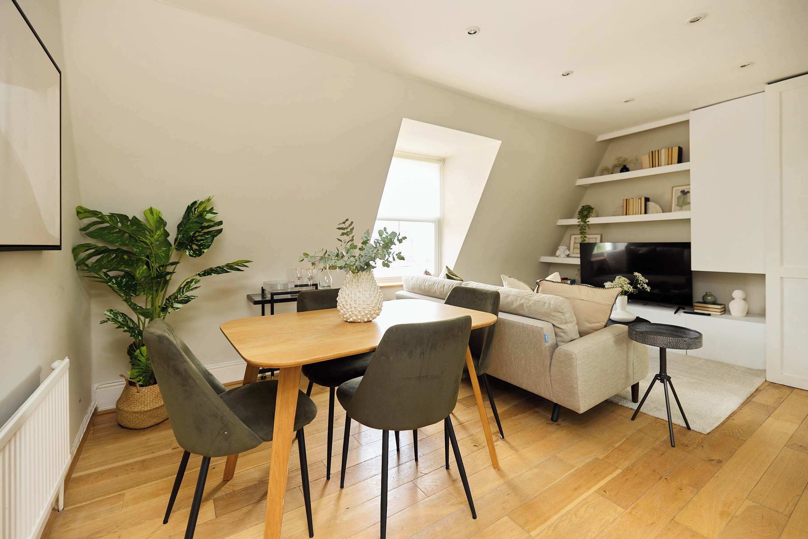 Un espace de vie moderne comprenant un coin repas, un canapé et un téléviseur.