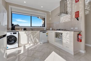 A modern kitchen with a built-in washer, dishwasher, and microwave. - Slow down and enjoy island life at Le Grand Villa 2 (Raymond Island)