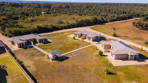 Una zona residencial con varias casas, un espacio abierto central y terreno boscoso circundante.