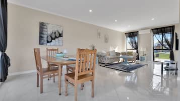 Un vaste espace de vie comprenant une table à manger, des chaises, des canapés et une table basse.
