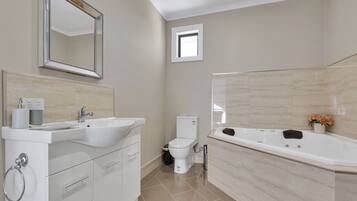 Une salle de bain avec un lavabo, des toilettes et une baignoire.