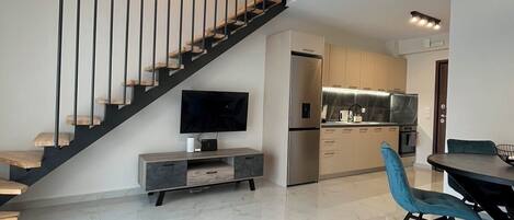 Una cocina moderna con horno empotrado y comedor con mesa y sillas.