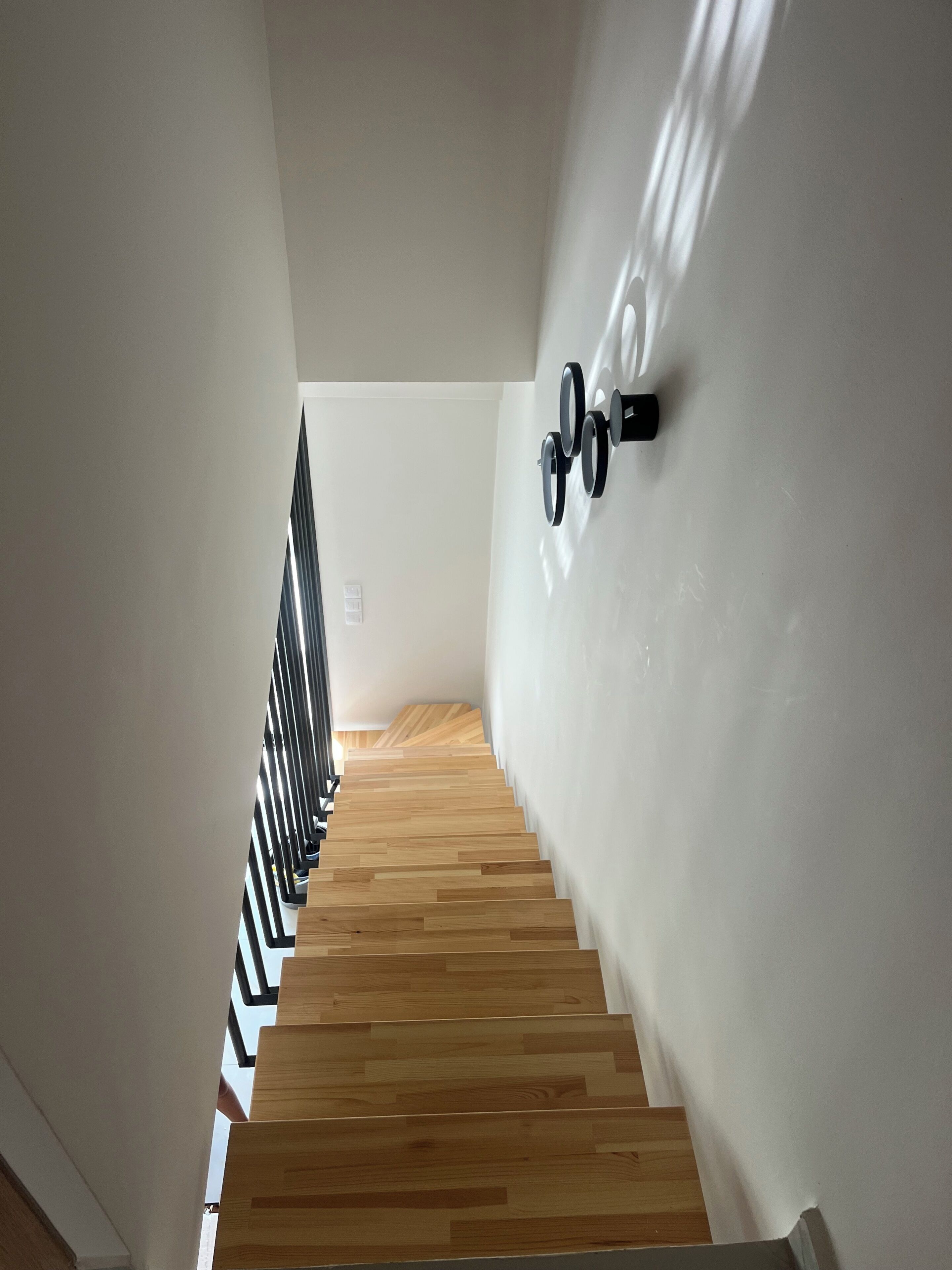 A staircase with wooden steps and a handrail, leading to an upper floor.