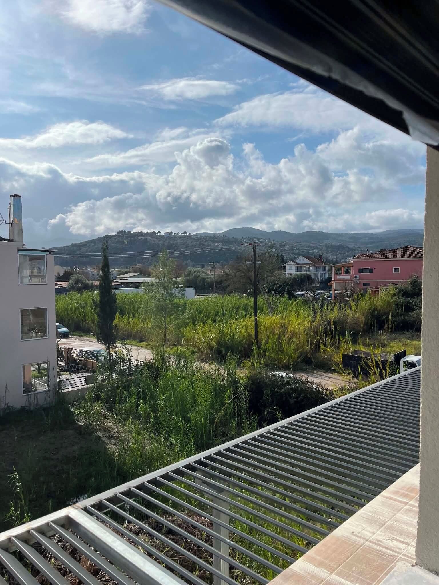 A residential area with a view of distant hills and a clear sky.
