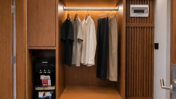 A walk-in closet with wooden paneling, a built-in coffee machine, and a bench.