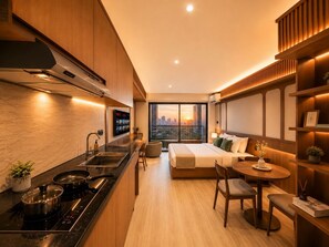 A modern hotel room with a kitchen, a dining area, and a large bed with a city view. - Solana Urban By SanLiving - Senayan (Jakarta)
