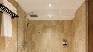 Un baño moderno con ducha envuelta en cristal, un inodoro y un lavabo.