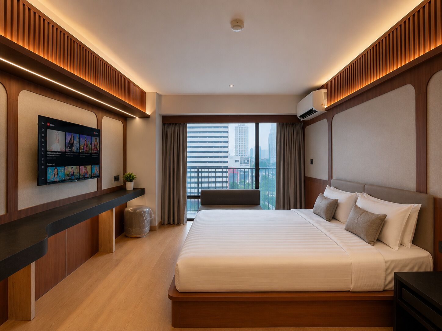 A modern hotel room with a large bed, a mounted TV, and a balcony with a city view.