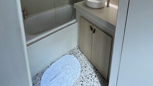 A modern bathroom with a bathtub, a sink, and a mirror. - Charming house in the city center (Angoulême)