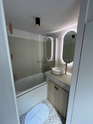 Een moderne badkamer met een bad, een wastafel en een spiegel.