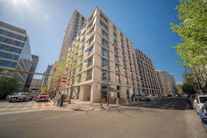 A multi-story hotel with a modern architectural design, featuring a prominent entrance and a visible parking area. - Apartment Krochmalna 61 (Warszawa)