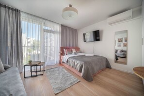 A modern bedroom with a bed, bedside table, and a TV mounted on the wall. - Apartment Krochmalna 61 (Warszawa)