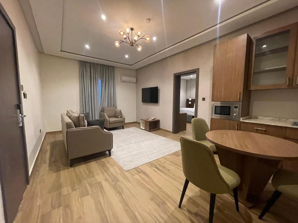 A modern living room with a sofa, chairs, a coffee table, and a TV.