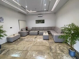 Uma sala de estar moderna com sofá seccional, mesa de centro e um vaso de planta.