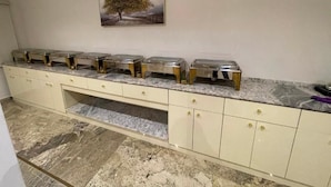Eine Küche mit Marmorarbeitsplatte, einem Spülbecken und einem Schrank mit Schubladen.