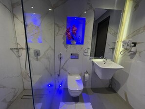 A modern bathroom with a glass-enclosed shower, a white toilet, and a vanity with a sink. - Checkinn Hotel And Resort (Jimeta)
