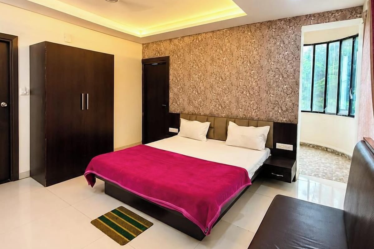 A modern bedroom with a large bed, a wardrobe, and a nightstand.