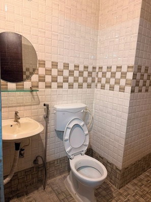 Un baño con inodoro, lavabo y espejo.