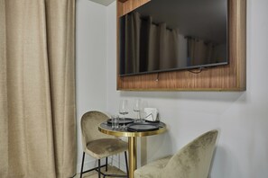A room with a round table, two chairs, a mirror, and a curtain. - New Apartment Center of Paris/le Marais (Paris)