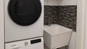 Un área de lavandería compacta con una lavadora Samsung y un lavabo blanco con el logotipo de bismart.