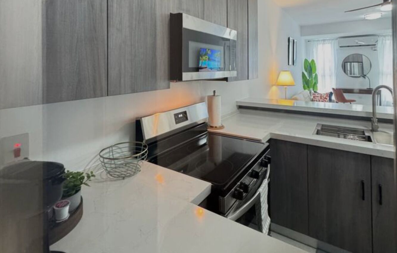 A modern kitchen with a built-in oven, a microwave, and a large window.