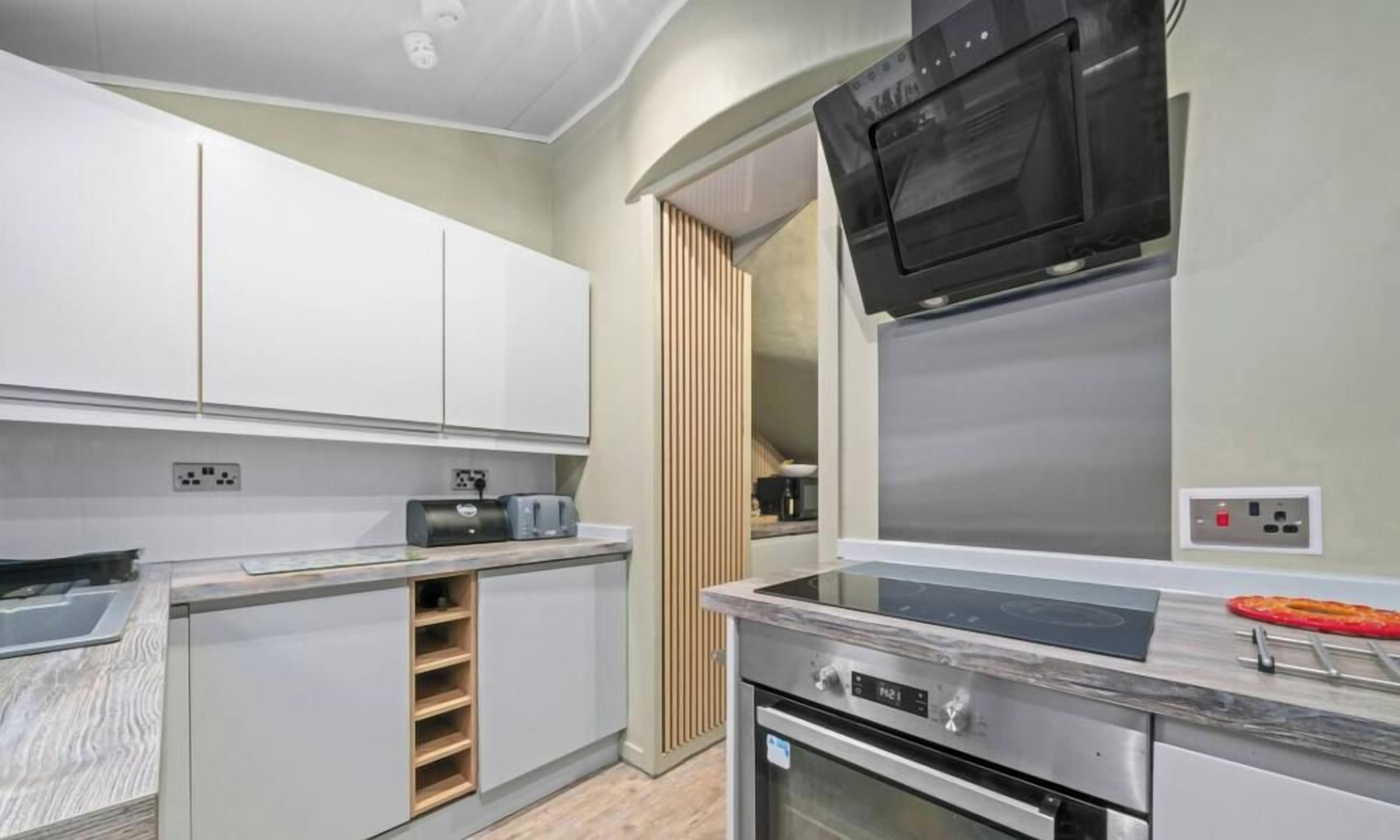 A modern kitchen with built-in appliances, a microwave, and a stove.