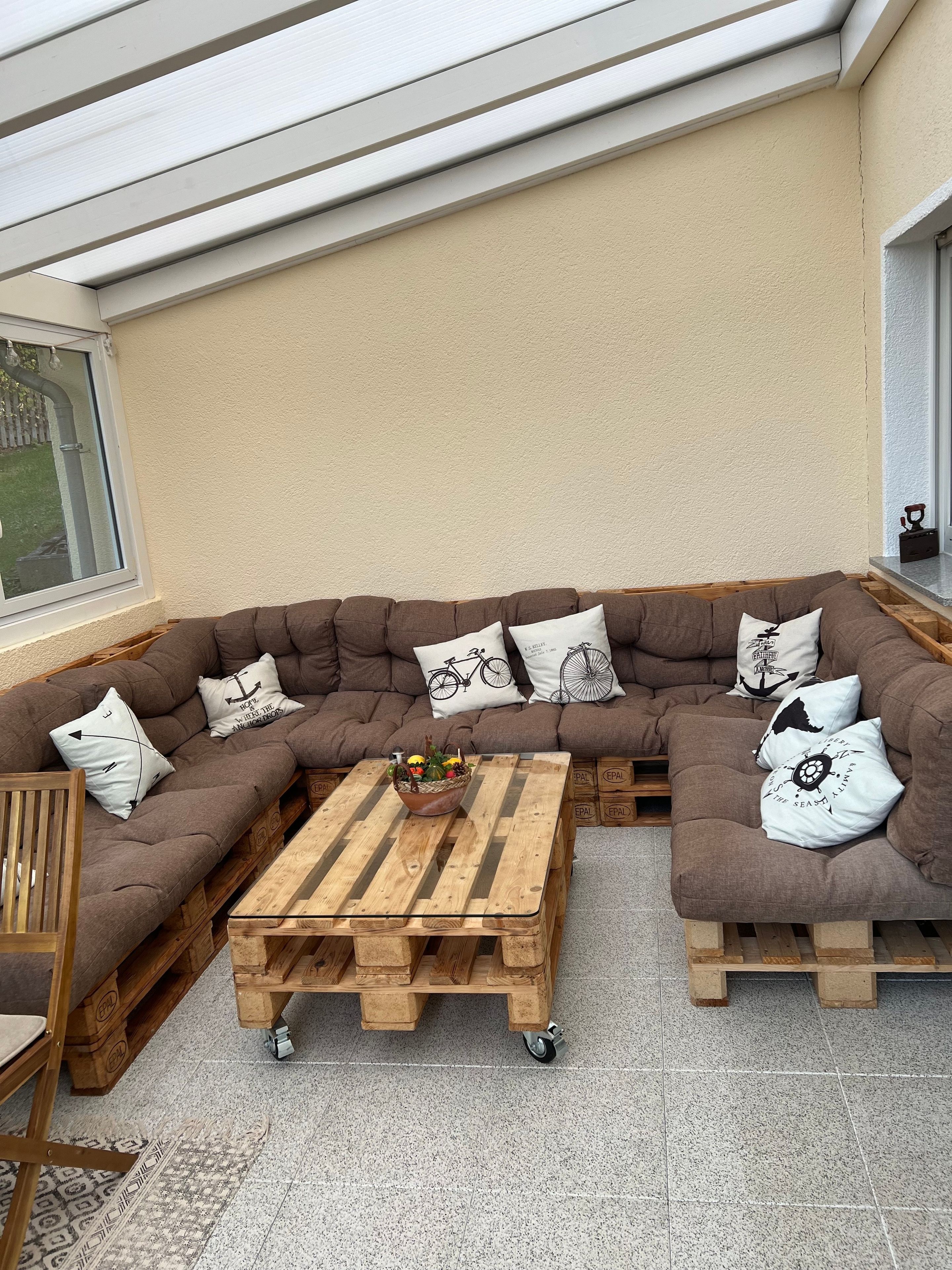 A cozy corner with a brown sectional sofa, a wooden coffee table, and decorative pillows.