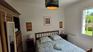 A bedroom with a bed, a window, a radiator, and a wardrobe. - A family home in Brittany, a ten-minute walk from Paimpol and its harbor (Ploubazlanec)