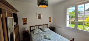 A bedroom with a bed, a window, a radiator, and a wardrobe. - A family home in Brittany, a ten-minute walk from Paimpol and its harbor (Ploubazlanec)
