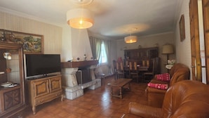 A traditional living room with a stone fireplace, leather sofa, and wooden furniture. - A family home in Brittany, a ten-minute walk from Paimpol and its harbor (Ploubazlanec)