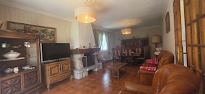 A traditional living room with a stone fireplace, leather sofa, and wooden furniture. - A family home in Brittany, a ten-minute walk from Paimpol and its harbor (Ploubazlanec)