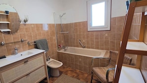 A bathroom with a bathtub, a sink, a mirror, and a shower. - A family home in Brittany, a ten-minute walk from Paimpol and its harbor (Ploubazlanec)