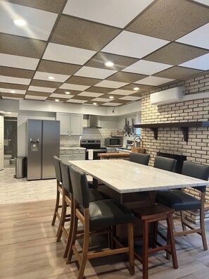Eine moderne Küche mit Marmorarbeitsplatte, Edelstahlgeräten und einer Karokku-Decke.