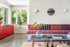 Een moderne woonkamer met een bank, een salontafel en een rode kast.