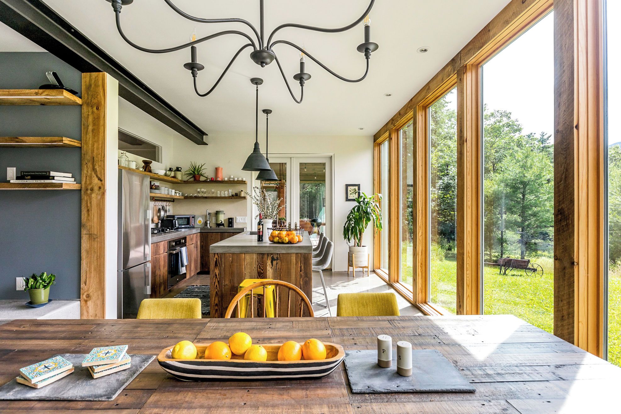 A modern kitchen with wooden cabinetry, a central island, and a dining area with a wooden table and chairs.