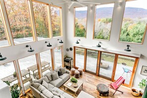 A spacious living area with a large window overlooking a scenic landscape. - The Windbourne A Luxury Retreat In The Catskills (Saugerties)