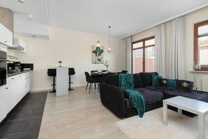A modern living space with a kitchen, dining area, and a sofa set. - Spacious Vervena Apartment with Terrace | Close to the Beach (Gdańsk)