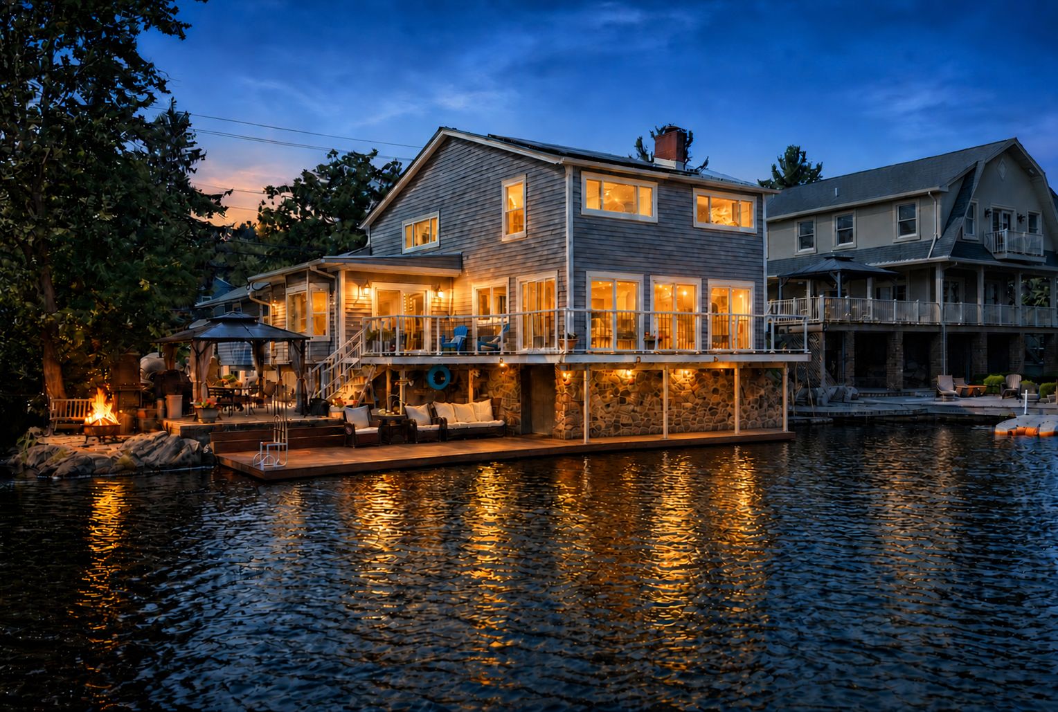 Ein Haus am Wasser mit Steg, Außenbereich und Feuerstelle.