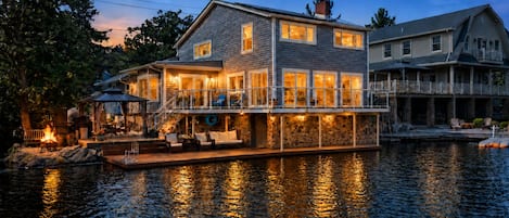 Ein Haus am Wasser mit Steg, Außenbereich und Feuerstelle.