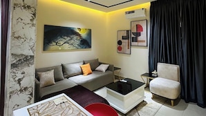 Un salon moderne avec un canapé, une table basse et un fauteuil.
