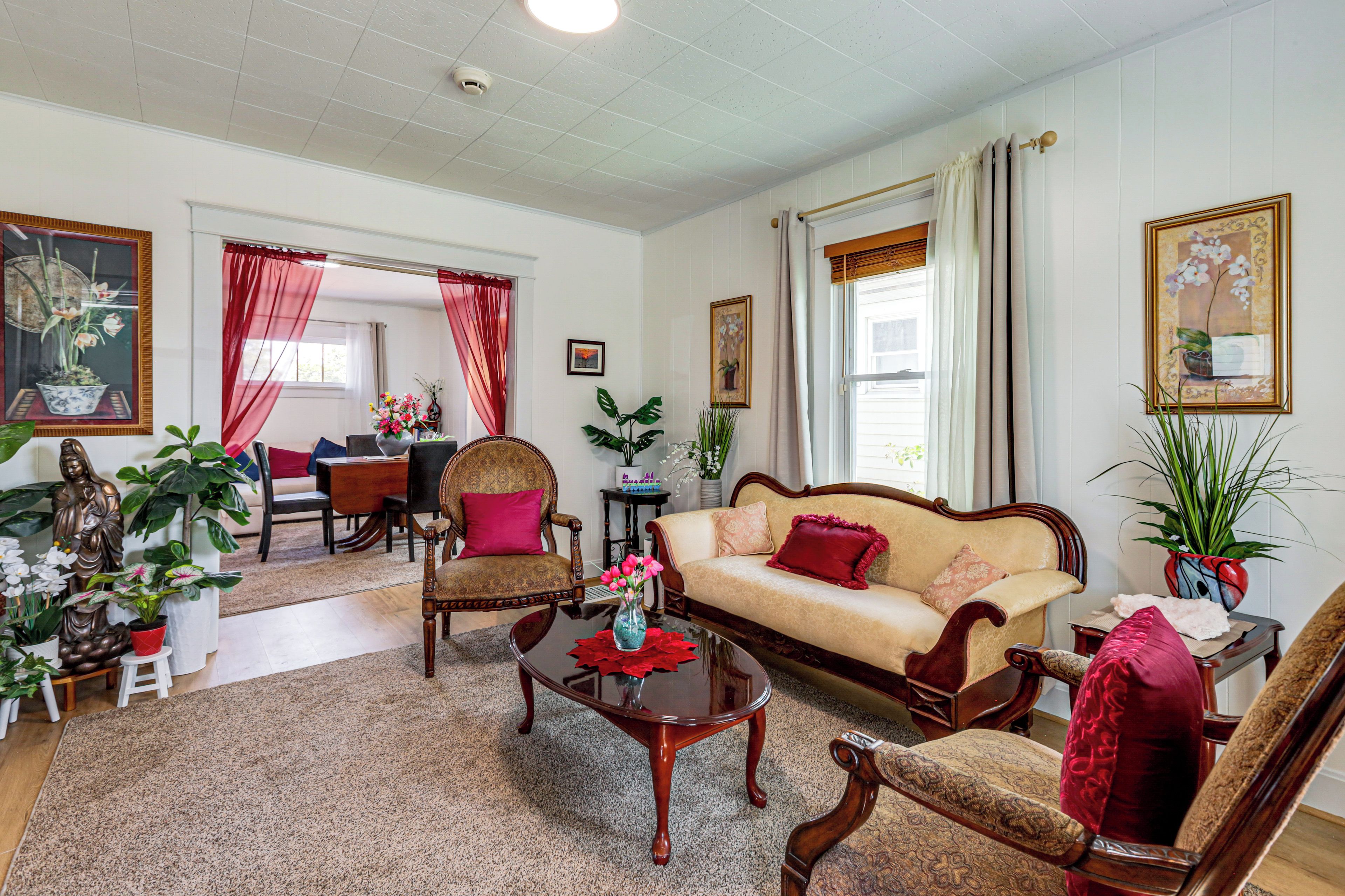 A traditional living room with a sofa, chairs, a coffee table, and various decorative items.