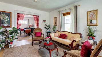 A traditional living room with a sofa, chairs, a coffee table, and various decorative items.