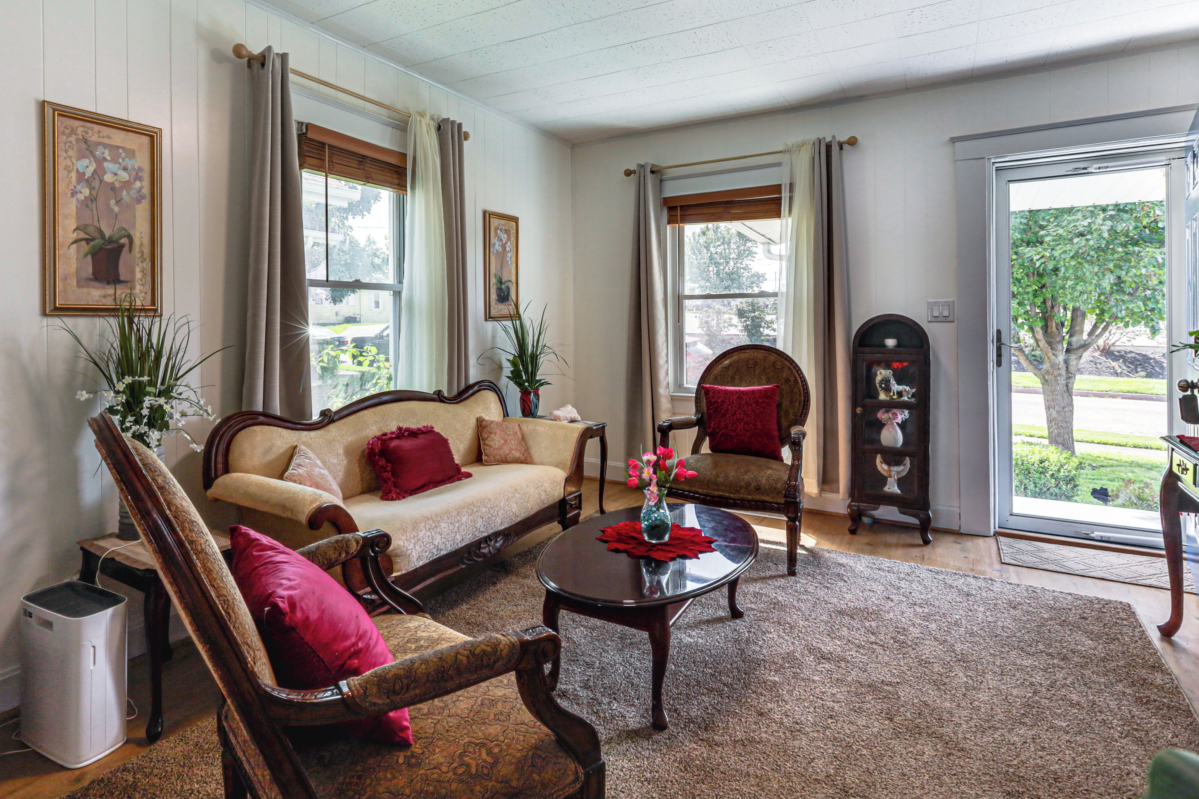A living room with a sofa, two armchairs, a coffee table, and a fireplace.