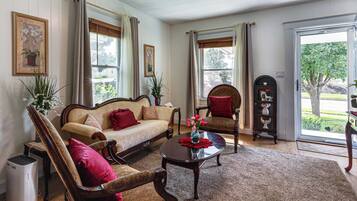 A living room with a sofa, two armchairs, a coffee table, and a fireplace.
