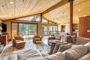 Un vaste espace de vie doté d’un haut plafond, de grandes fenêtres et d’un coin salon confortable.