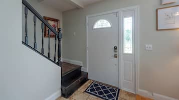 A staircase with a handrail and a door with a glass panel and a lock.