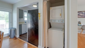 A compact kitchen with a dishwasher, a small refrigerator, and a window with blinds. - Hudson Valley Duplex: Hike, Sip + Explore! (Highland)