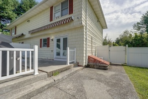 A two-story house with a front porch, a white fence, and a small front yard. - Hudson Valley Duplex: Hike, Sip + Explore! (Highland)